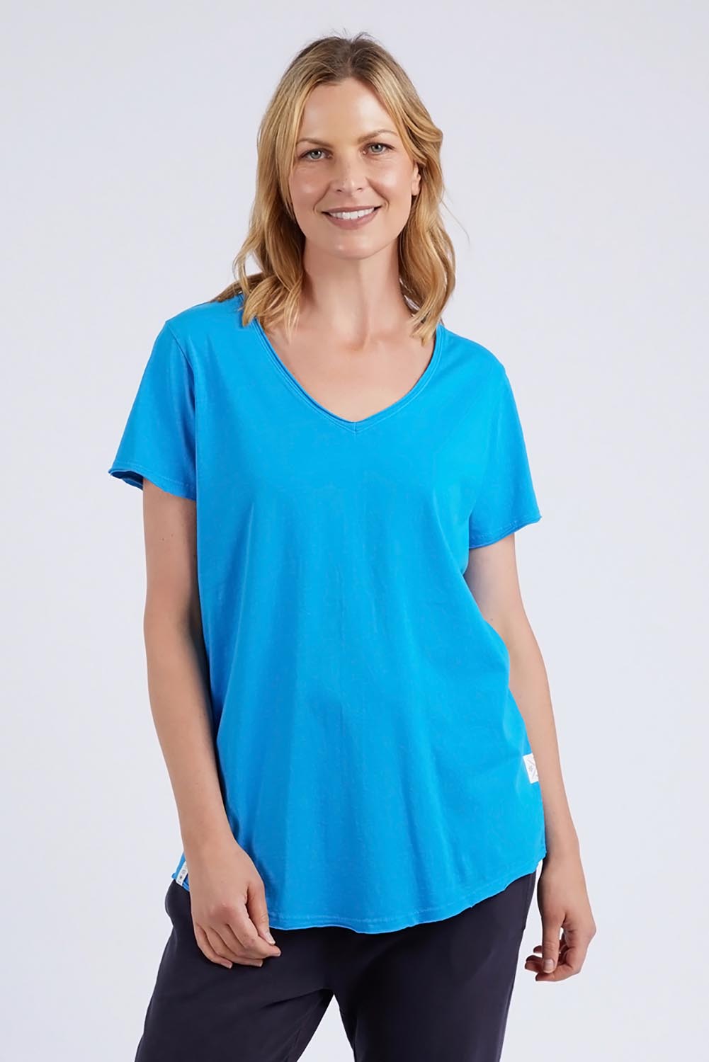 A model wearing the Fundamental Vee Cotton Tee in colour Ibizablue (Blue), from the front, cropped image