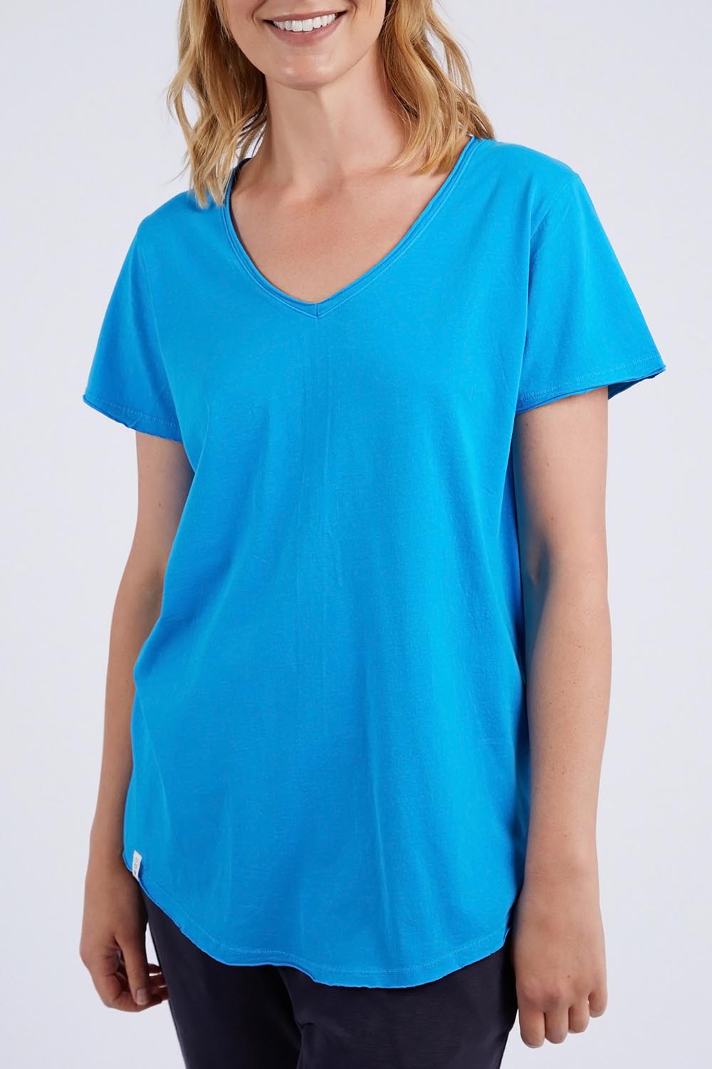 A model wearing the Fundamental Vee Cotton Tee in colour Ibizablue (Blue), from the front, cropped image