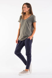A model wearing the Fundamental Vee Cotton Tee in colour Khaki (Green), from the front, showing the whole outfit
