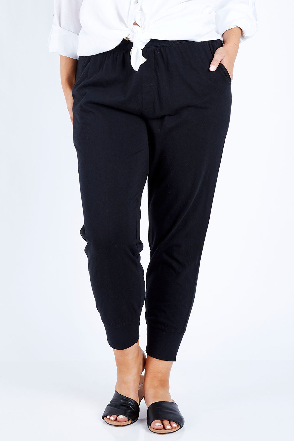 Model Jess wearing size 14 of the Fundamental Wash Out Pant in colour Black (Black), from the front, cropped image