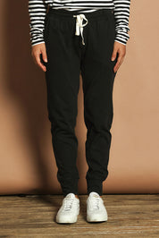 Model Katie wearing size 10 of the Fundamental Wash Out Pant in colour Black (Black), from the front, cropped image