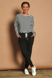 Model Katie wearing size 10 of the Fundamental Wash Out Pant in colour Black (Black), from the front, showing the whole outfit