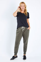 Model Bianca wearing size 10 of the Fundamental Wash Out Pant in colour Darkkhaki (Green), from the front, showing the whole outfit