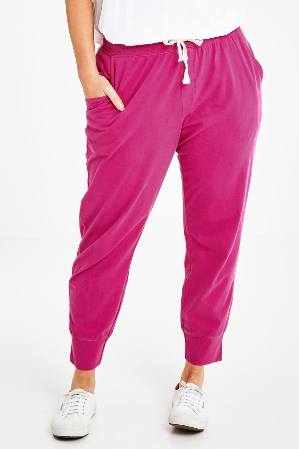 Model Laura wearing size 14 of the Fundamental Wash Out Pant in colour Plum (Pink), from the front, cropped image