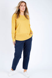 Model Jess wearing size 14 of the Fundamental Rib Long Sleeve Tee in colour Mustard, from the front, showing the whole outfit