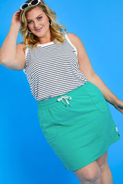 Model Caitlin wearing size 20 of the Fundamental Cassie Skirt in colour Brghtgreen (Green), from the front, showing the whole outfit