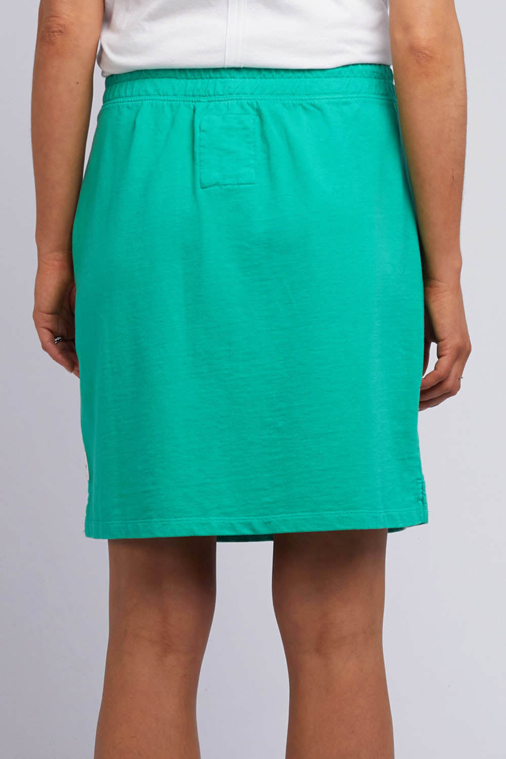 A model wearing the Fundamental Cassie Skirt in colour Brghtgreen (Green), from the back
