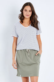 Model Elhana wearing size 10 of the Fundamental Cassie Skirt in colour Khaki (Green), from the front, cropped image