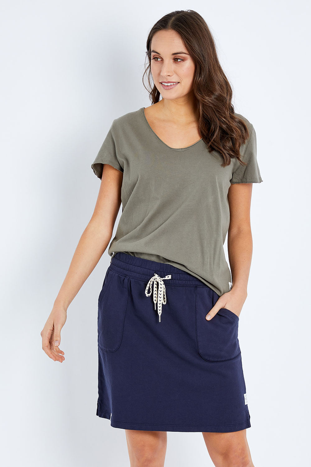 Model Elhana wearing size 10 of the Fundamental Cassie Skirt in colour Navy (Blue), from the front, cropped image