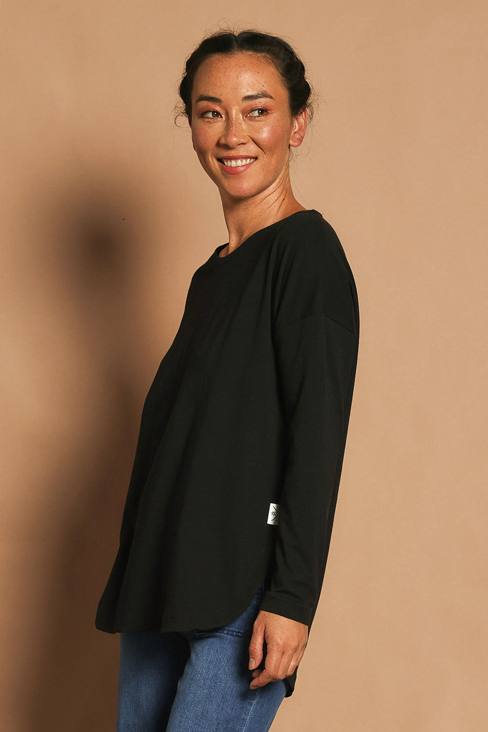 Model Katie wearing size 10 of the Fundamental Society L/S Tee in colour Black (Black), from the front, showing the whole outfit