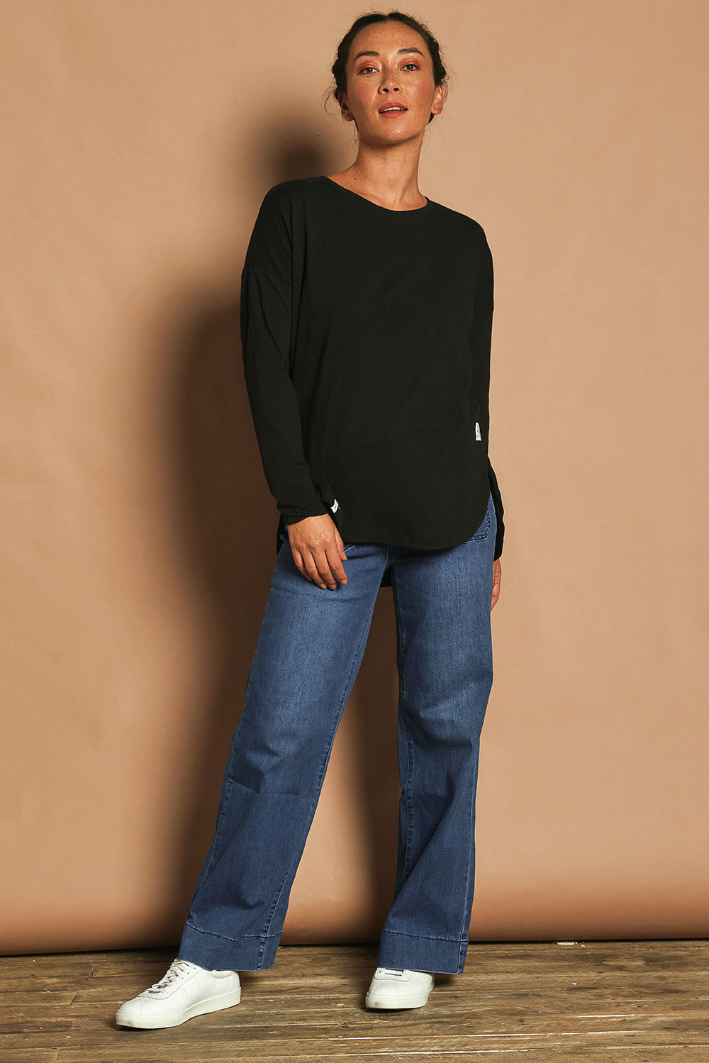 Model Katie wearing size 10 of the Fundamental Society L/S Tee in colour Black (Black), from the front, showing the whole outfit