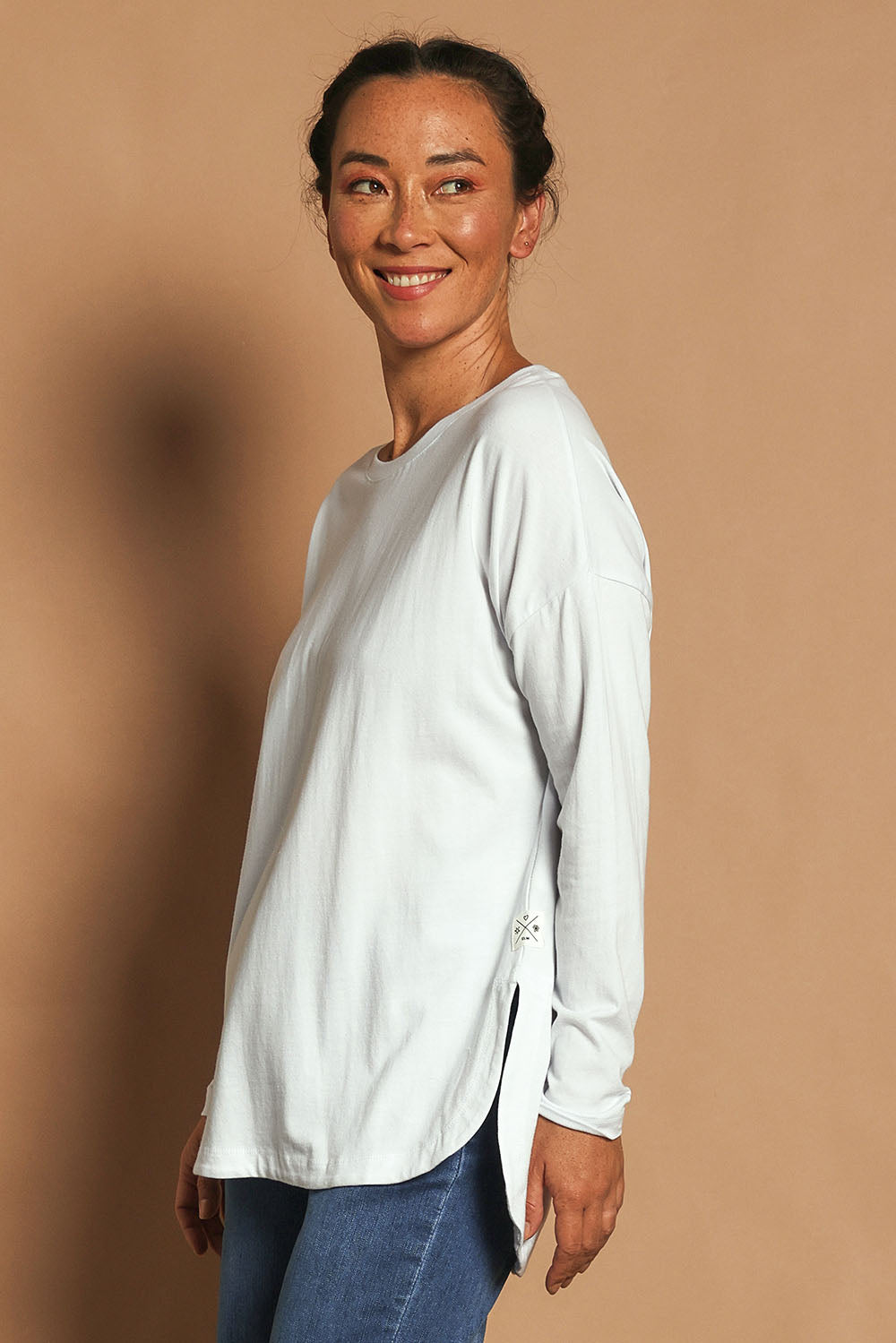 Model Katie wearing size 10 of the Fundamental Society L/S Tee in colour White (White), from the front, showing the whole outfit