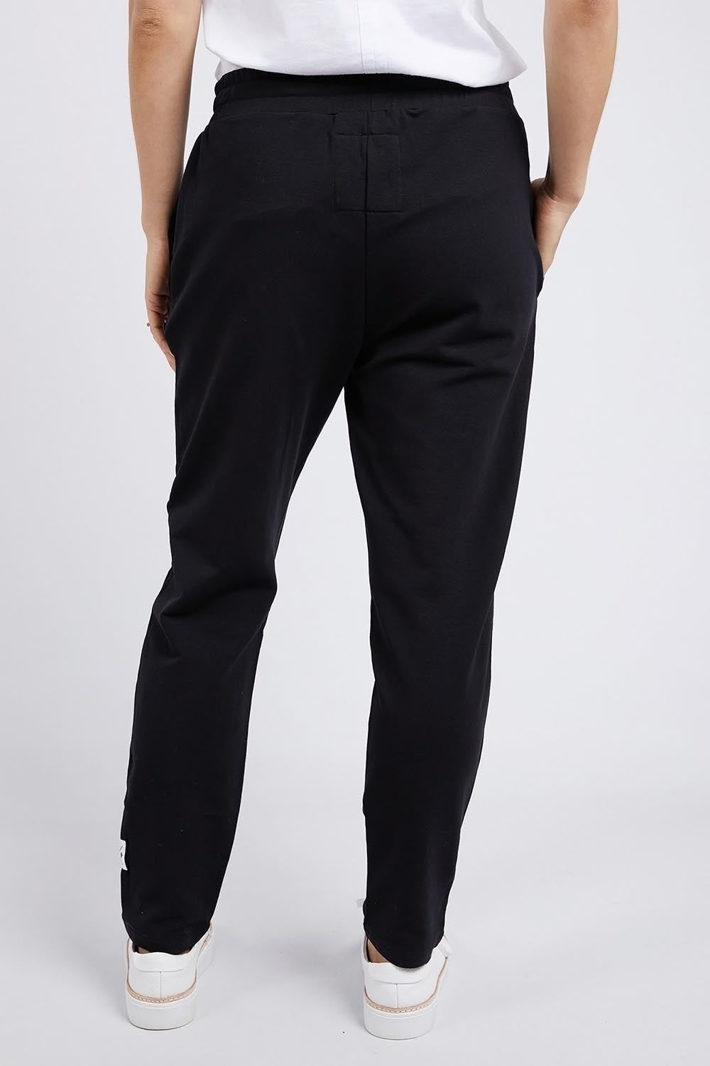 A model wearing the Fundamental Lobby Pant in colour Black (Black), from the front, cropped image