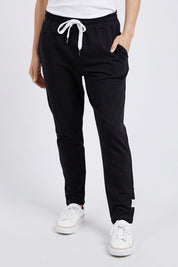 A model wearing the Fundamental Lobby Pant in colour Black (Black), from the front, cropped image