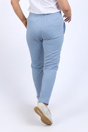 A model wearing the Fundamental Lobby Pant in colour Steelblue (Blue), from the back