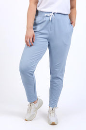 A model wearing the Fundamental Lobby Pant in colour Steelblue (Blue), from the front, cropped image