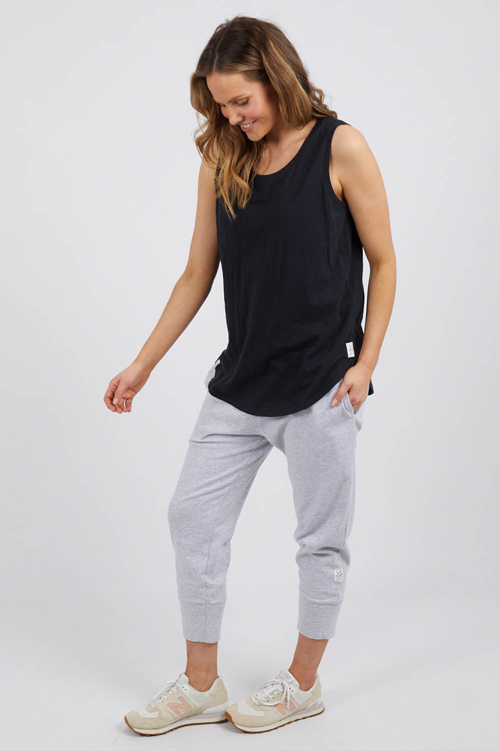 A model wearing the Fundamental Scoop Tank in colour Black (Black), from the front, showing the whole outfit