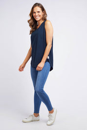 A model wearing the Fundamental Scoop Tank in colour Navy (Blue), from the front, showing the whole outfit