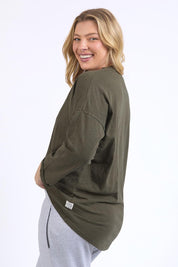 A model wearing the Fundamental Annie 3/4 Sleeve Tee in colour Basil (Green), from the back