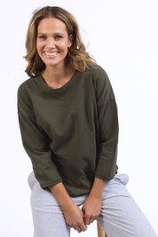 A model wearing the Fundamental Annie 3/4 Sleeve Tee in colour Basil (Green), from the front, cropped image
