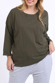 A model wearing the Fundamental Annie 3/4 Sleeve Tee in colour Basil (Green), from the front, cropped image