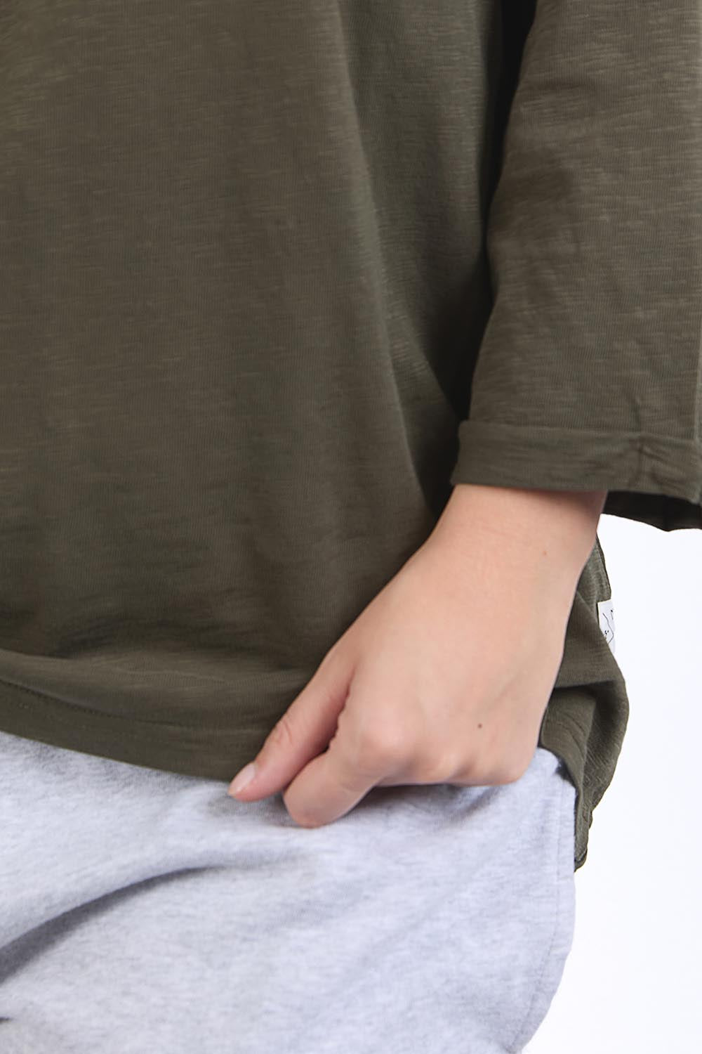 A model wearing the Fundamental Annie 3/4 Sleeve Tee in colour Basil (Green), from the front, cropped image