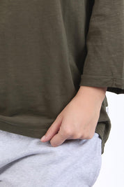 A model wearing the Fundamental Annie 3/4 Sleeve Tee in colour Basil (Green), from the front, cropped image