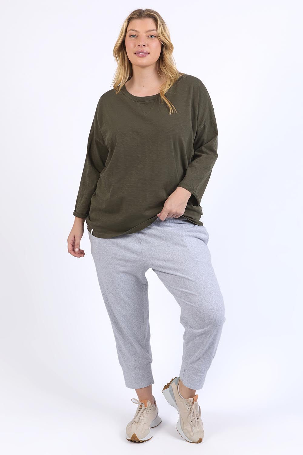 A model wearing the Fundamental Annie 3/4 Sleeve Tee in colour Basil (Green), from the front, showing the whole outfit