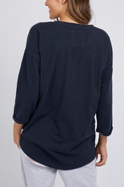 A model wearing the Fundamental Annie 3/4 Sleeve Tee in colour Navy (Blue), from the back