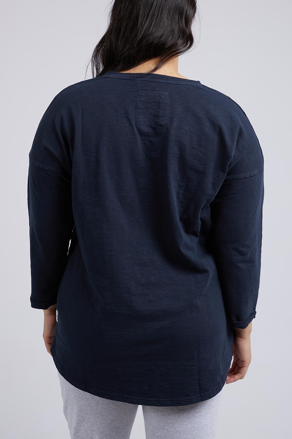 A model wearing the Fundamental Annie 3/4 Sleeve Tee in colour Navy (Blue), from the back