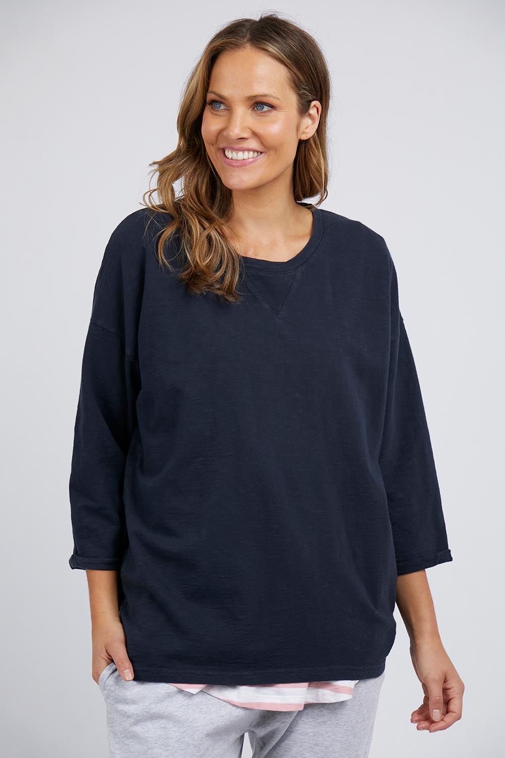 A model wearing the Fundamental Annie 3/4 Sleeve Tee in colour Navy (Blue), from the front, cropped image