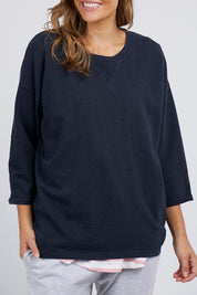 A model wearing the Fundamental Annie 3/4 Sleeve Tee in colour Navy (Blue), from the front, cropped image
