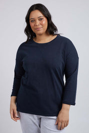 A model wearing the Fundamental Annie 3/4 Sleeve Tee in colour Navy (Blue), from the front, cropped image