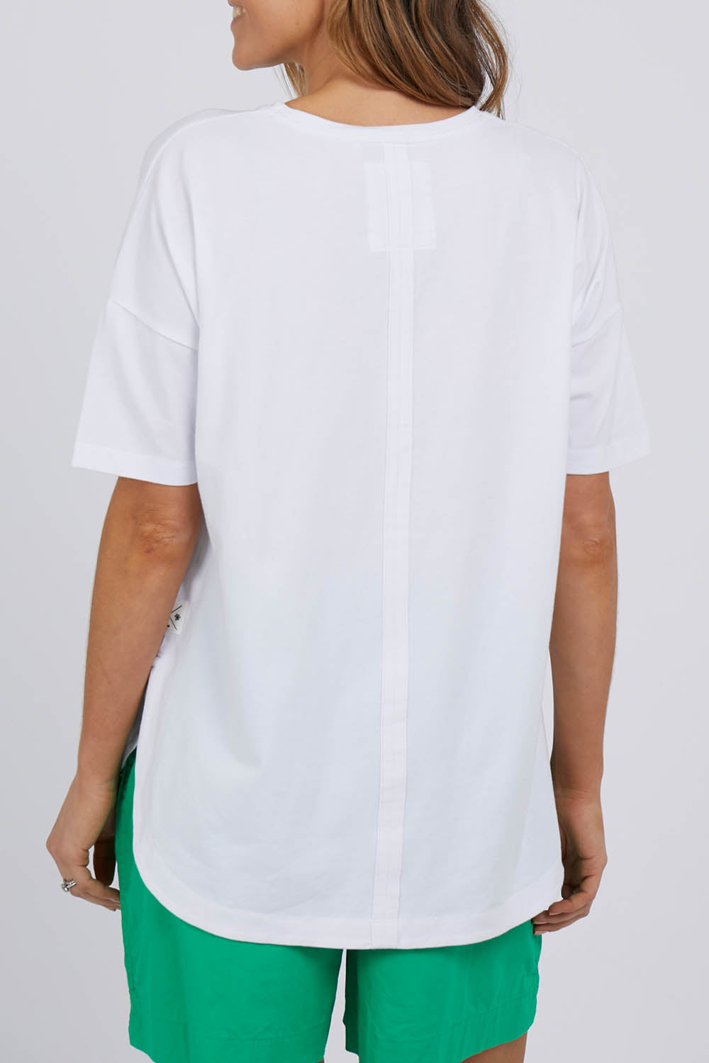 A model wearing the Fundamental Soceity S/S Tee in colour White (White), from the back
