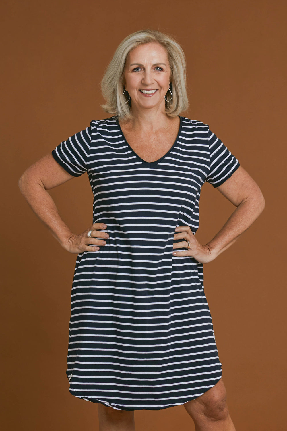 Model Sandy wearing size 10 of the Fundamental Mary Stripe Dress in colour Navy (Blue), from the front, cropped image