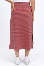 A model wearing the Fundamental Cotton Travel Skirt in colour Watermelon (Red), from the back