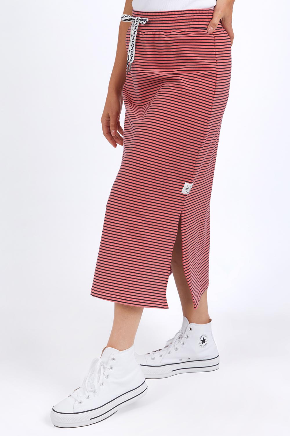 A model wearing the Fundamental Cotton Travel Skirt in colour Watermelon (Red), from the front, cropped image