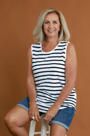 Model Sandy wearing size 10 of the Fundamental Scoop Tank in colour Navywhit (Blue), from the front, cropped image