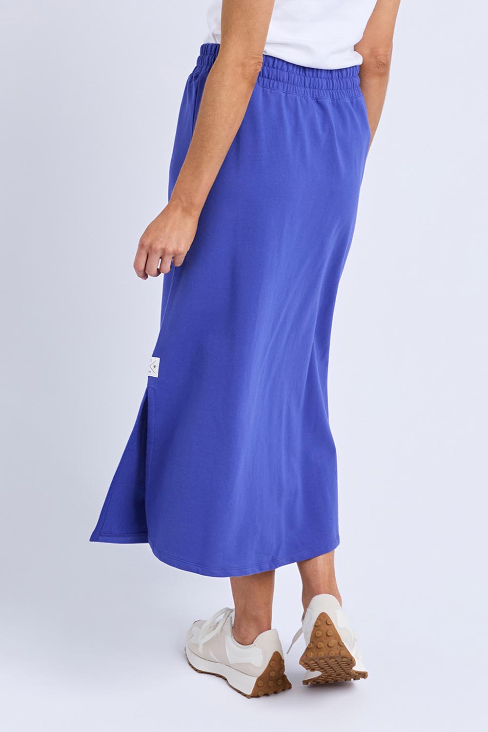 A model wearing the Fundamental Travel Skirt in colour Oceanblue (Blue), from the back