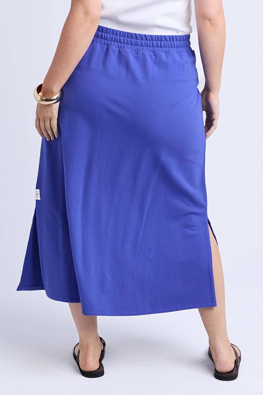 A model wearing the Fundamental Travel Skirt in colour Oceanblue (Blue), from the back