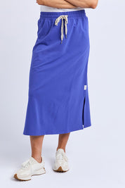 A model wearing the Fundamental Travel Skirt in colour Oceanblue (Blue), from the front, cropped image