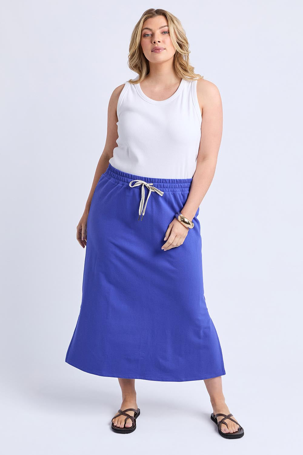 A model wearing the Fundamental Travel Skirt in colour Oceanblue (Blue), from the front, showing the whole outfit