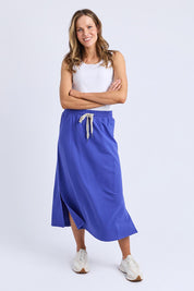A model wearing the Fundamental Travel Skirt in colour Oceanblue (Blue), from the front, showing the whole outfit