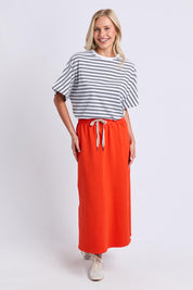 Model Genericm wearing size sample of the Fundamental Travel Skirt – Tangello in colour Tangello, from the front