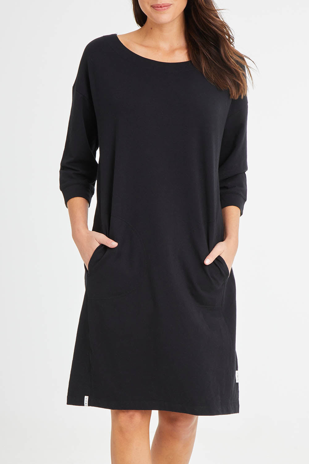 Model Madeline wearing size 10 of the Fundamentals Carolina Fleece Dress in colour Black (Black), from the front, cropped image