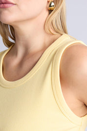 A model wearing the Fundamental Rib Crew Cotton Tank in colour Banana, from the front, cropped image