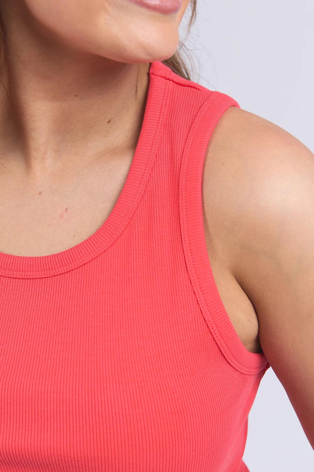 A model wearing the Fundamental Rib Crew Cotton Tank in colour Cayenne (Red), from the front, cropped image