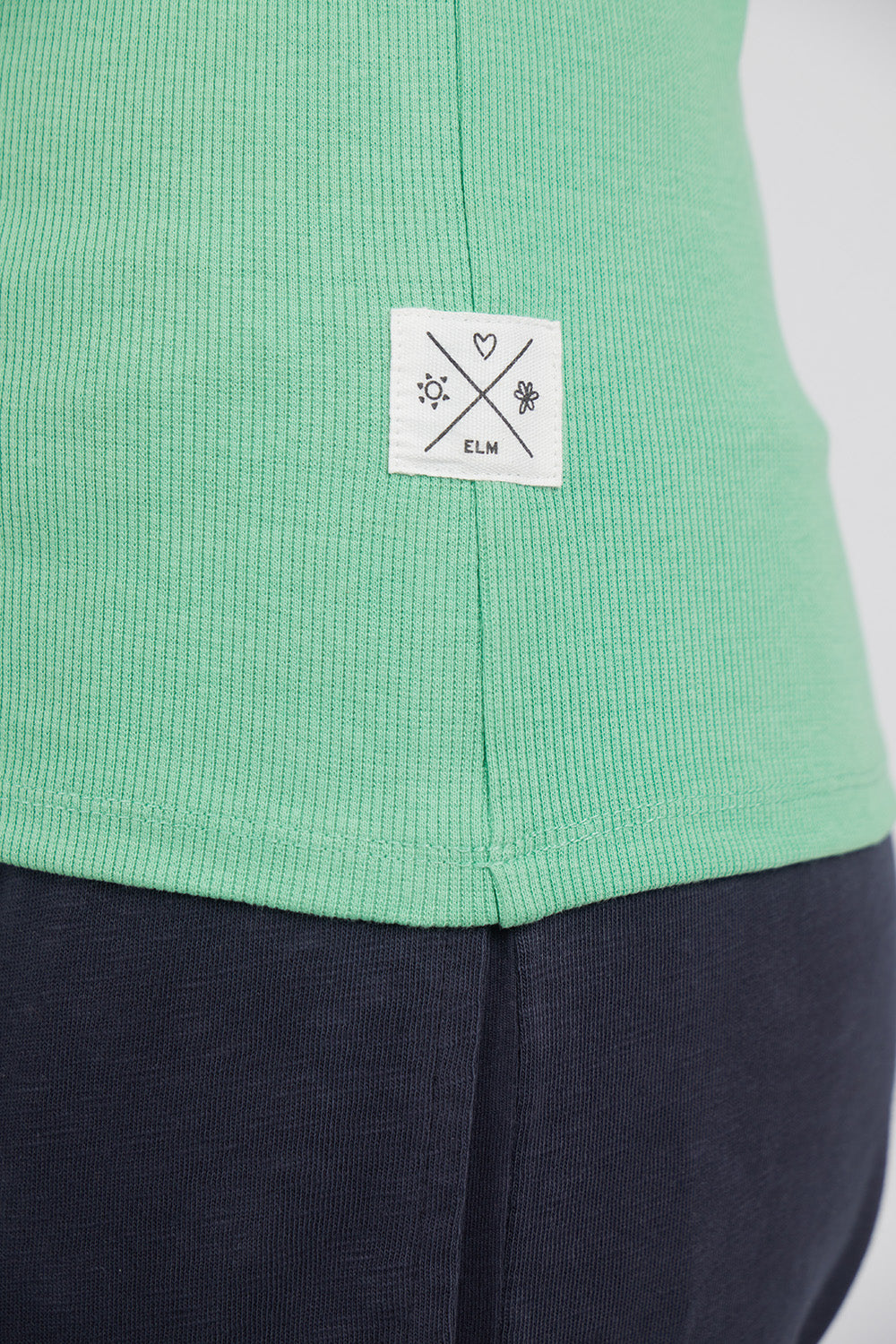 A model wearing the Fundamental Rib Crew Cotton Tank in colour Meadow (Green), from the front, cropped image