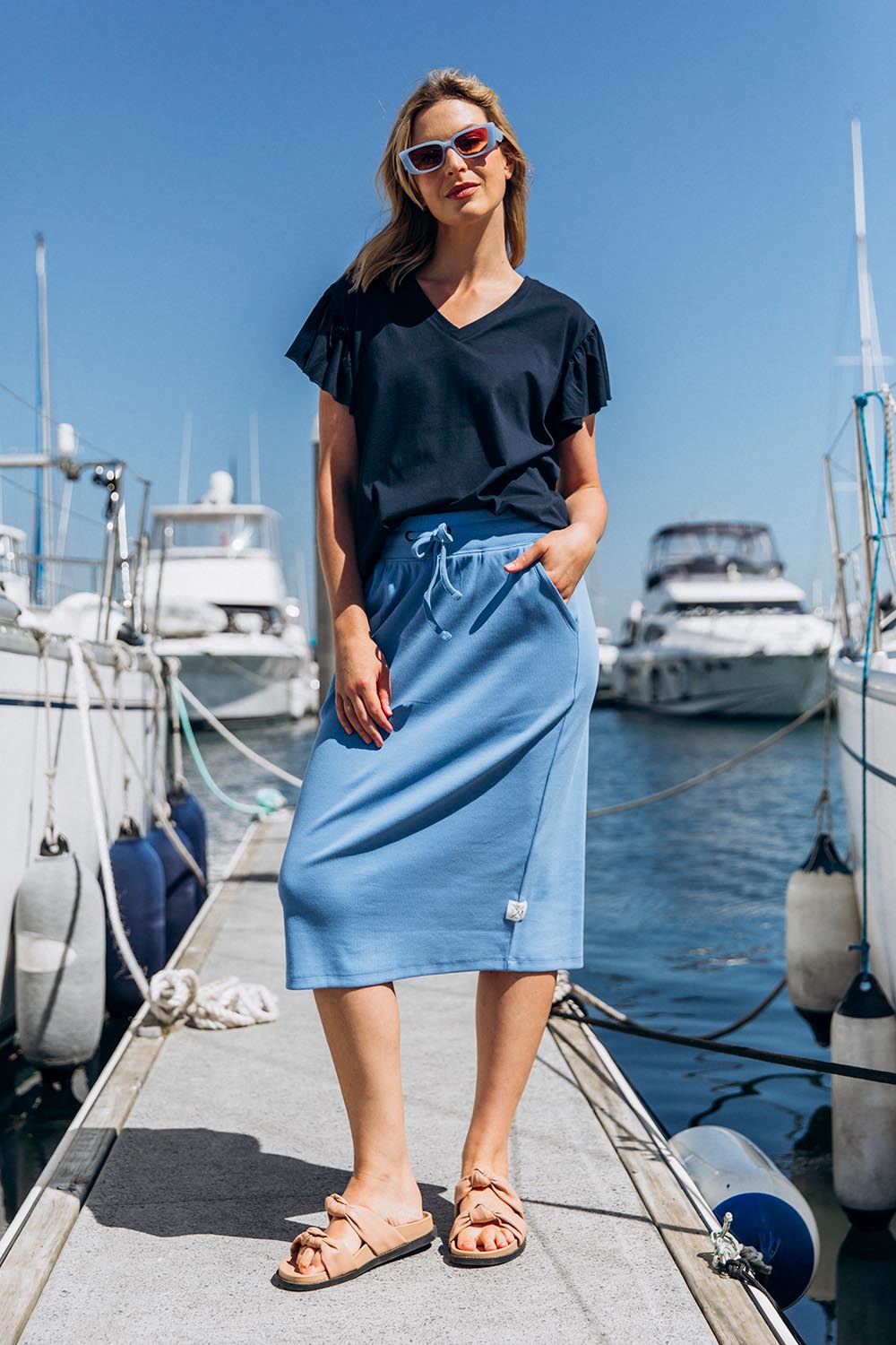 A model wearing the Fundamental Rib Midi Skirt in colour Cerulblue (Blue), from the front, showing the whole outfit