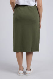 A model wearing the Fundamental Rib Midi Skirt in colour Clover (Green), from the back